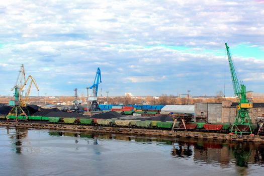 Baltic coal terminal with port cranes near the river. Riga cargo