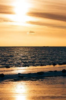 Vertical view of golden sunset at Baltic sea shore