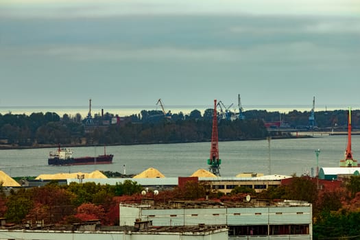 Black cargo ship moving to Baltic sea past the residential area