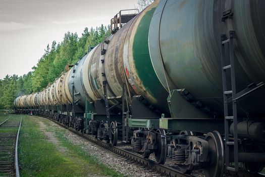 Tank wagons with oil. Freight train in forest