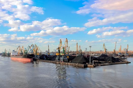 Baltic coal terminal with port cranes near the river. Riga cargo