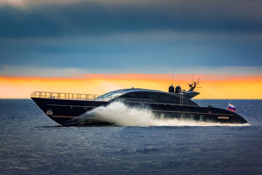 Black elite speed motor boat moving fast from Baltic sea