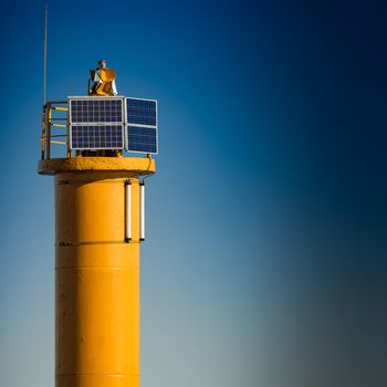 Yellow lighthouse on breakwater dam in Riga, Europe