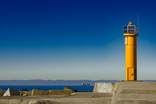 Yellow lighthouse on breakwater dam in Riga, Europe