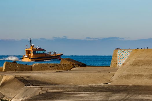 Yellow pilot ship moving at speed from the Baltic sea