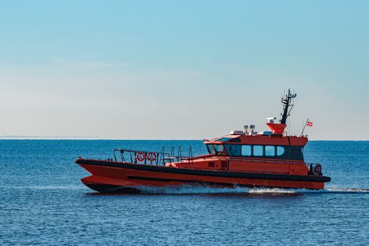 Orange pilot ship moving fast from Baltic sea