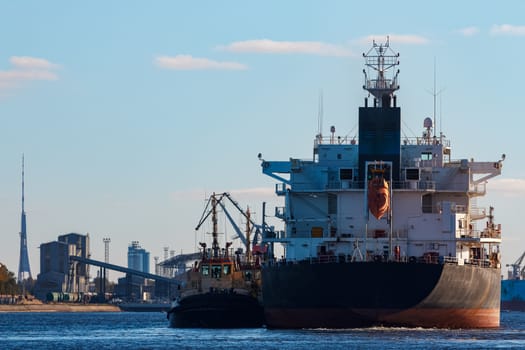 Black cargo ship entering the port of Riga, Europe