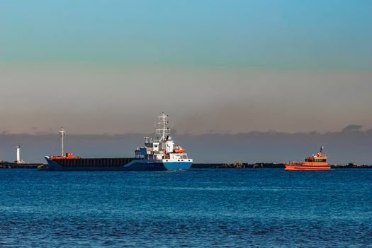 Blue cargo ship leaving Riga and entering Baltic sea