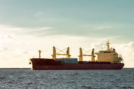 Red cargo ship moving entering the port of Riga