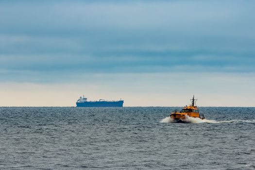 Orange pilot ship moving at speed in Baltic sea