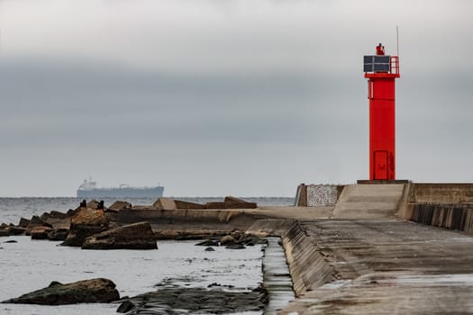 Breakwater dam with red lighthouse in Riga, Europe