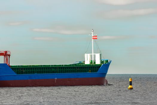 Blue cargo ship's bow leaving the port of Riga