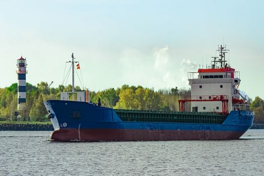 Blue cargo ship leaving the port of Riga at sunny day