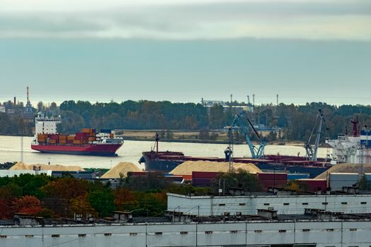 Red container ship entering port of Riga, Latvia
