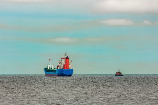 Blue cargo ship entering the Baltic sea. Riga, Europe