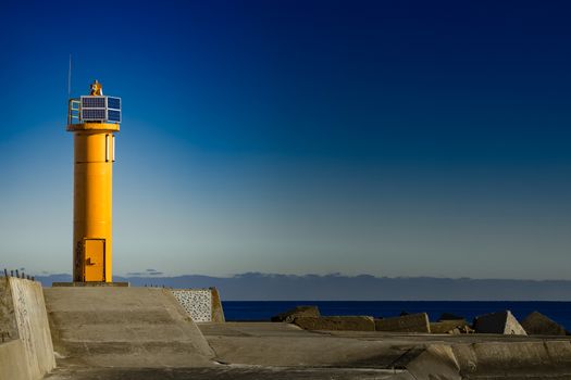 Yellow lighthouse on breakwater dam in Riga, Europe