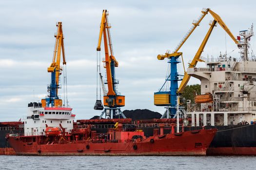 Red cargo ship loading in the port of Riga, Europe