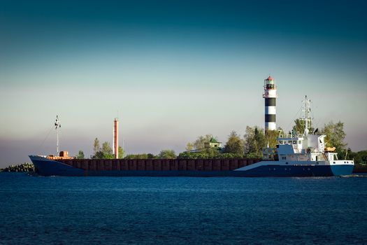 Blue cargo ship leaving Riga and entering Baltic sea