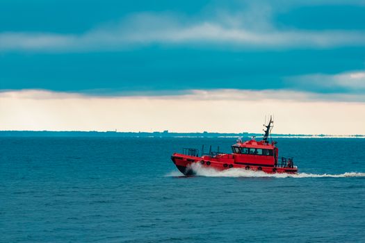 Red pilot ship moving at speed from Baltic sea