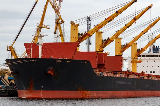 Black cargo ship loading in the port of Riga, Europe