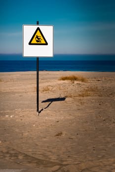 Yellow warning sign on summer beach, Riga