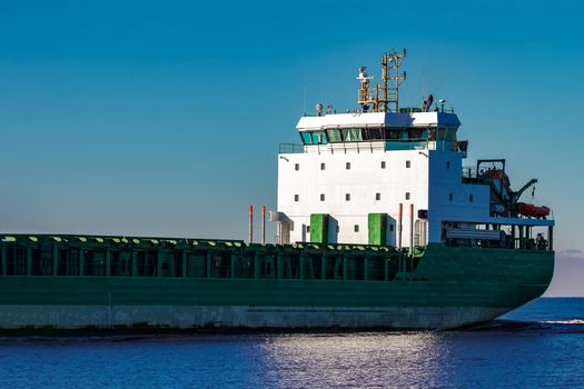 Green cargo ship's cabin in still Baltic sea water, Riga