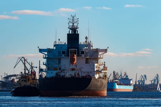 Black cargo ship entering the port of Riga, Europe