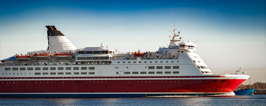 Red cruise liner. Passenger ferry ship sailing in still water