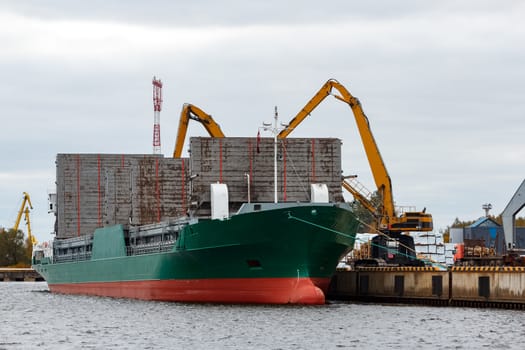 Green cargo ship loading in the port of Riga, Europe