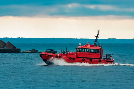 Red pilot ship moving fast from Baltic sea