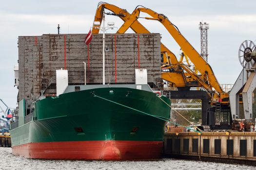 Green cargo ship loading in the port of Riga, Europe