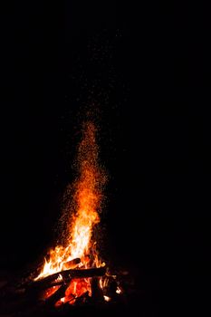 Campfire with flying sparks isolated on black background