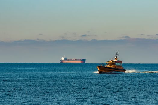 Yellow pilot ship moving at speed from the Baltic sea