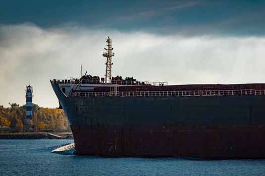 Black cargo ship's bow entering Riga, Europe