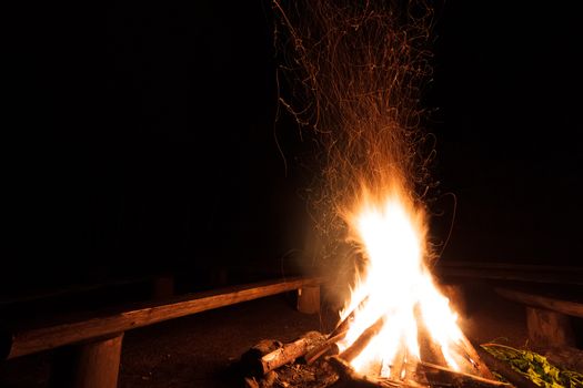 Campfire with flying sparks in the night