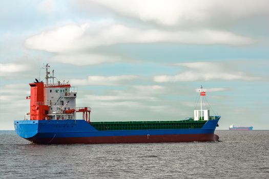 Blue cargo ship entering the Baltic sea. Riga, Europe