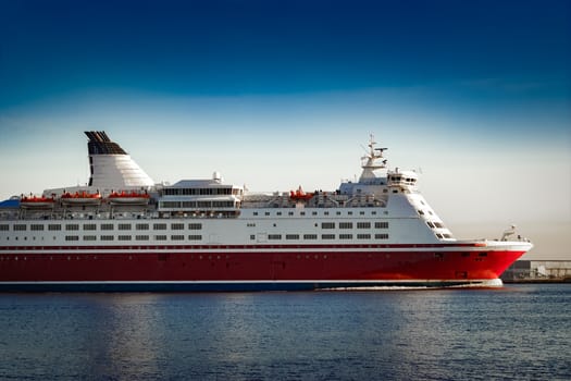 Red cruise liner. Passenger ferry ship sailing in still water