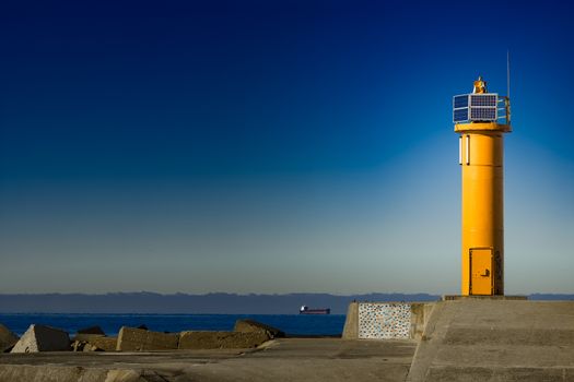 Yellow lighthouse on breakwater dam in Riga, Europe