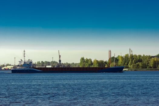 Blue cargo ship leaving Riga and entering Baltic sea