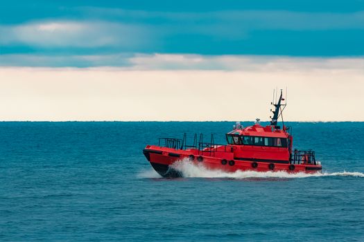 Red pilot ship moving at speed from Baltic sea