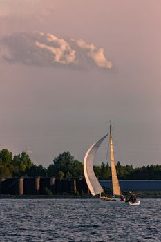 Sailboat moving on Daugava river in evening, Latvia