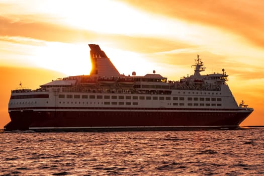 Cruise liner leaving Riga. Passenger ferry sailing at hot sunset