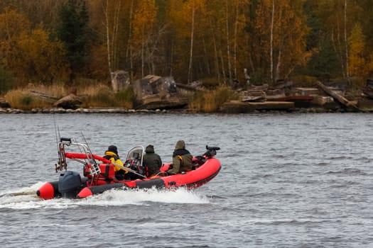 Red inflatable boat with fishermans moving at speed