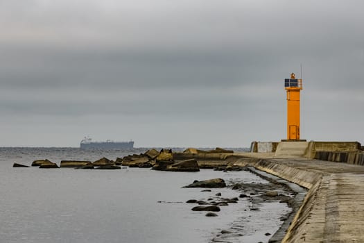 Breakwater dam with yellow lighthouse in Riga, Europe