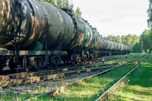 Tank wagons with oil. Freight train in forest