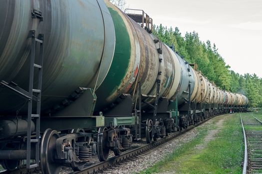 Tank wagons with oil. Freight train in forest