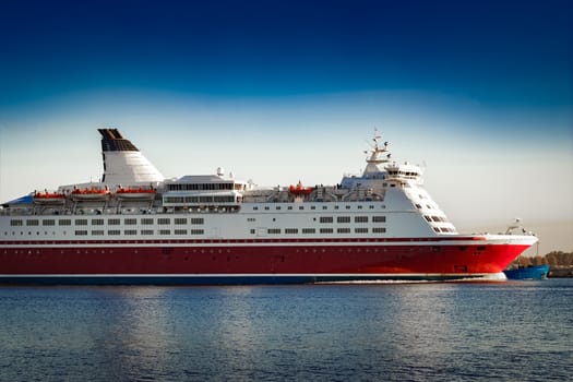 Red cruise liner. Passenger ferry ship sailing in still water