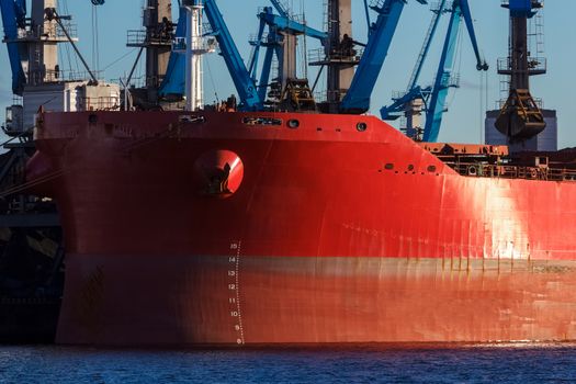 Red cargo ship loading in the port of Riga, Europe