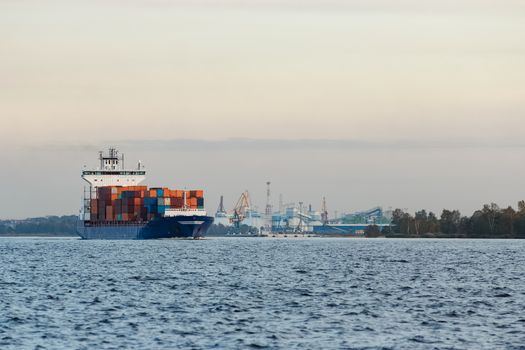 Blue container ship moving to Baltic sea. Riga, Latvia