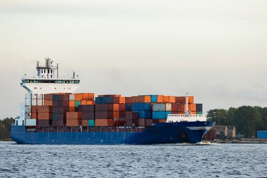 Blue container ship moving to Baltic sea. Riga, Latvia